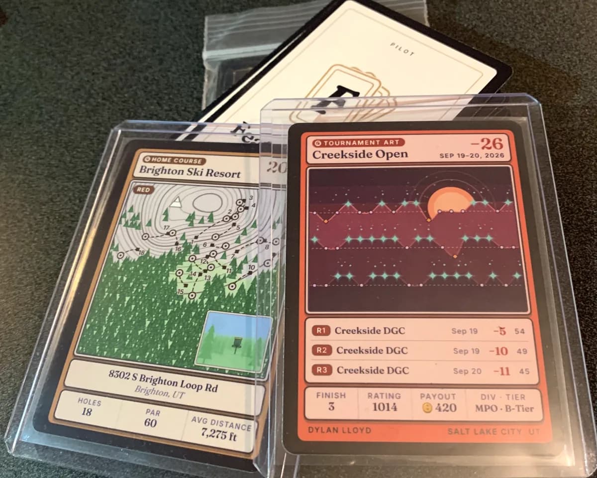 Two printed Feature Cards, a Home Course card and a Tournament Art card, resting on a card back